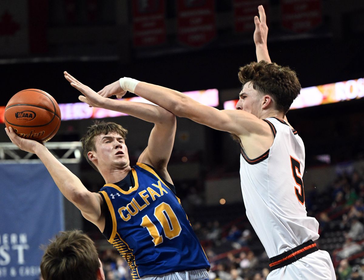Colfax guard Jayce Kelly (10) tries to shoot past Napavine guard Karsen Denault (5) during the first half of a WIAA State 2B semifinal high school basketball game, Friday, Feb. 29, 2024, in the Spokane Veterans Arena.  (COLIN MULVANY)