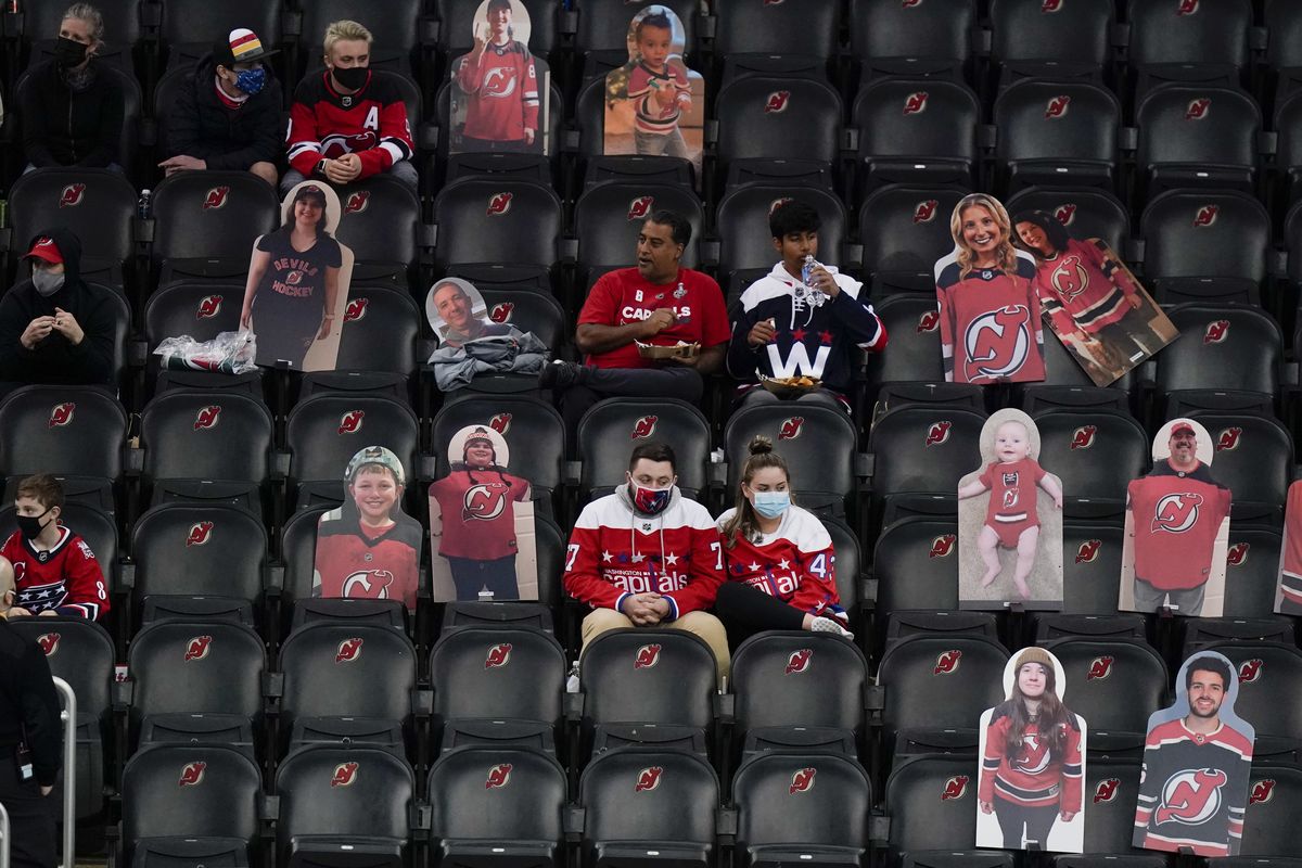 Washington Capitals fans sit among cutouts of New Jersey Devils fans on April 4 as they watch the second period in Newark, N.J.  (Frank Franklin II)
