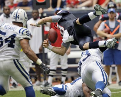 Houston quarterback Sage Rosenfels (18) fumbles as he flies over Indianapolis defensive end Dwight Freeney (93).  (Associated Press / The Spokesman-Review)