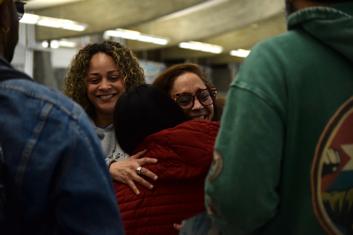 Karla Tiul Baltazar, 10, hugs Olga Lucia Herrera, right, after coming off a plane from Denver on Saturday at Spokane International Airport. She was with her father, Arnoldo Tiul Caal. State Rep. Natasha Hill, left, was part of the group who greeted them.  (Alexandra Duggan/Spokesman-Review)