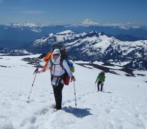 Carrie Ringo Carlquist and other Spokane Mountain enjoy spectacular views during their slog up the Muir Snowfield the day before they began their summit bid on Mount Rainier. That's the Tatoosh Range, Goat Rocks Wilderness and Mount Adams in the background.