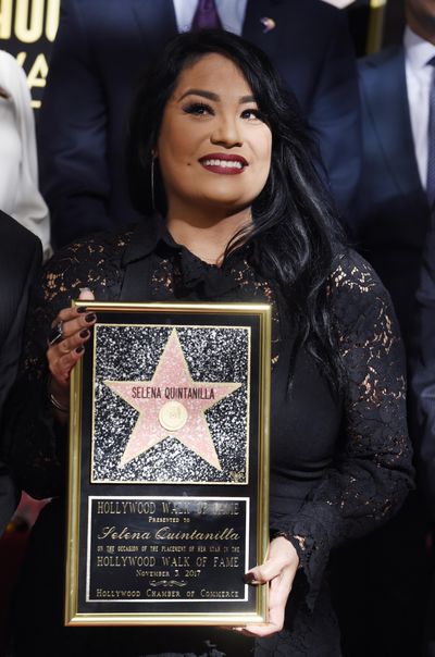 Suzette Quintanilla, sister of the late singer Selena Quintanilla, holds a replica of her sister's star on the Hollywood Walk of Fame during a posthumous star ceremony on Friday, Nov. 3, 2017, in Los Angeles. (Chris Pizzello / Associated Press)