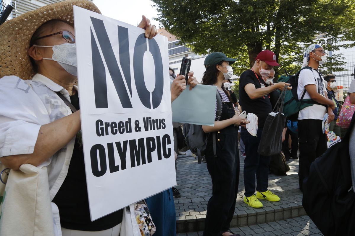 People gather for a rally in Tokyo’s Shinjuku shopping district Sunday, July 18, 2021, to protest against the Olympics starting from July 23. They held signs that said No Olympics.  (Yuri Kageyaman)