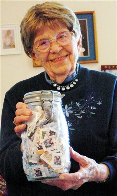 n this June 25, 2012, photo, Polly Nikolaisen, 91, poses for a photo with a jar of stamps. Working through the Sons of Norway Fedraheimen Lodge No. 140, Nikolaisen and her friends sort, trim and weigh canceled stamps gathered from local businesses and individuals to send to a Norwegian institution called Tubfrim. The organization sells the stamps to collectors to raise money for tuberculosis research as well as to help disabled children.  (Candace Chase / AP Photo/The Daily Inter Lake)