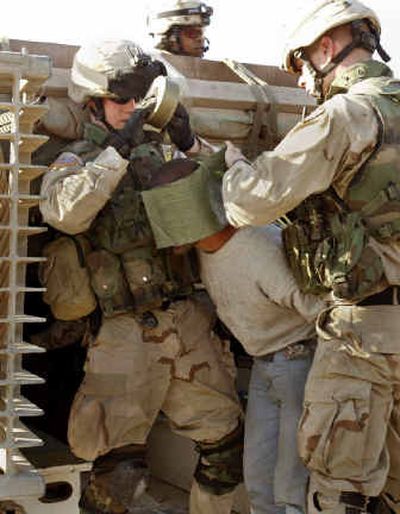 
U.S. Army soldiers detain a suspected insurgent after raiding a tea shop in Mosul, Iraq. Violence still convulses the city, with attacks against U.S. and Iraqi forces continuing and explosions and gunfire ripping through frigid skies almost nightly.
 (Associated Press / The Spokesman-Review)