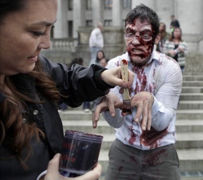 Actor David S. Hogan gets prepped for his role by makeup artist Akemi Hart on the filming set inspired by the Syfy Network series “Z-Nation” on the Capitol grounds in Olympia on Tuesday. (Associated Press)