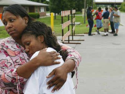 
Denise Pledger, left, comforts her cousin Deya Barnett outside the ConAgra Foods plant in Kansas City, Kan., Saturday. Barnett's father, uncle and cousin were among those killed during a shooting in the plant on Friday. 
 (Associated Press / The Spokesman-Review)