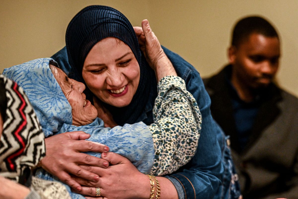 Shah Sulten, left, from Afghanistan, hugs Refugee Elders program coordinator Bushra Alshalah during an ESL class on Oct. 18, 2024, in Spokane.  (Kathy Plonka/The Spokesman-Review)