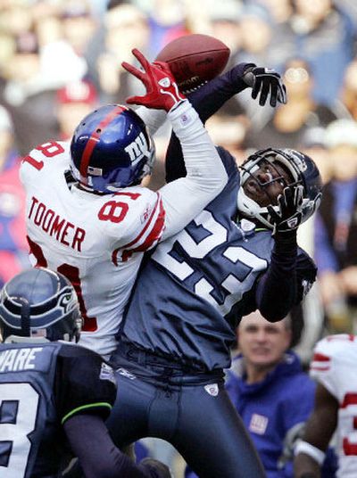
Seattle's Marcus Trufant knocks a third-down pass away from New York receiver Amani Toomer in the second quarter on Sunday.
 (Associated Press / The Spokesman-Review)