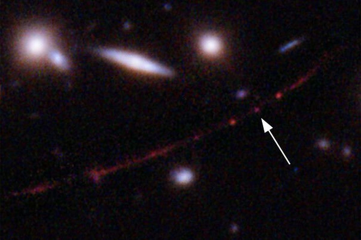 This image made available by NASA on Wednesday, March 30, 2022, shows the star Earendel, indicated by arrow, and the Sunrise Arc galaxy, stretching from lower left to upper right, optically bent due to a massive galaxy cluster between it and the Hubble Space Telescope which captured the light. The mass of the galaxy cluster serves as a magnifying glass, allowing Earendel to be seen. (NASA, ESA, Brian Welch (JHU), Dan Coe (STScI); Image processing: NASA, ESA, Alyssa Pagan via AP)  (HOGP)