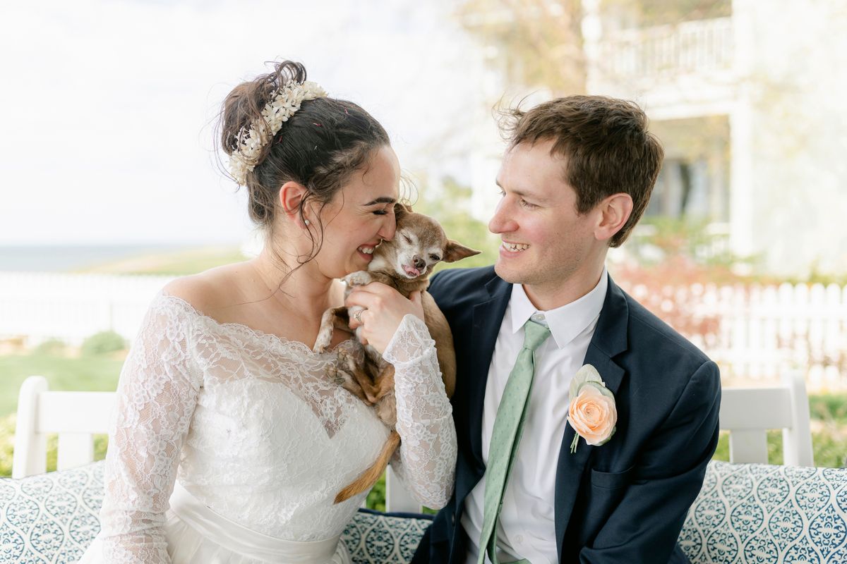 Caitlin Koska, left, and Michael White appear with their 14-year-old rescue dog, Luna, at their wedding on May 1 in St. Joseph, Mich. The couple adopted the pet after her owner died through Tyson’s Place Animal Rescue, a specialized organization focused on helping the terminally ill and seniors headed to residential care.  (Cat Carty Buswell)