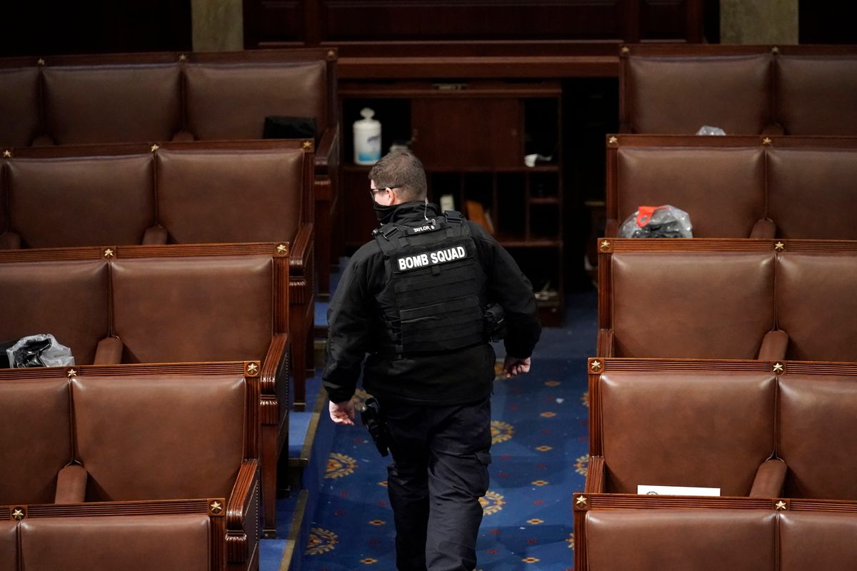 A member of the bomb squad walks on the House floor after rioters who support President Donald Trump broke into the U.S. Capitol on Jan. 6, 2021, in Washington. Intelligence reports compiled by the U.S. Capitol Police in the days before last year's insurrection envisioned only an improbable or remote risk of violence, even as other assessments warned that crowds of potentially tens of thousands of pro-Trump demonstrators could converge in Washington to create a dangerous situation.  (J. Scott Applewhite)