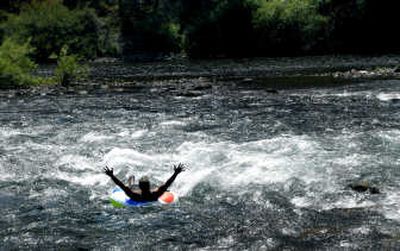 
Dave Clawson, of Spokane, floats down the Spokane River near the T.J. Meenach Bridge on Friday.  Residents are not the only ones suffering in the heat; low snowpack and a dry summer have left many rivers and lakes below normal levels. 
 (Photos by Brian Plonka / The Spokesman-Review)