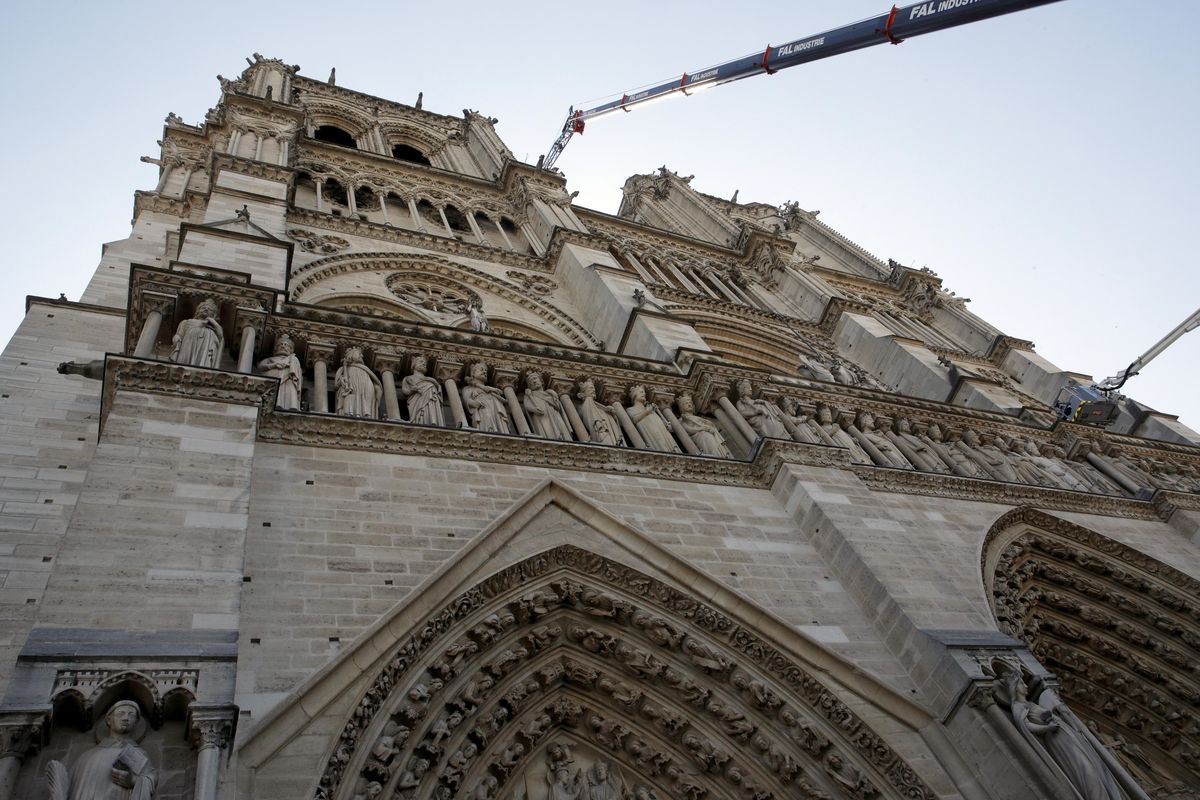 A crane works at Notre-Dame cathedral in Paris, Friday, April 19, 2019. Rebuilding Notre Dame, the 800-year-old Paris cathedral devastated by fire this week, will cost billions of dollars as architects, historians and artisans work to preserve the medieval landmark. (Philippe Wojazer / Associated Press)