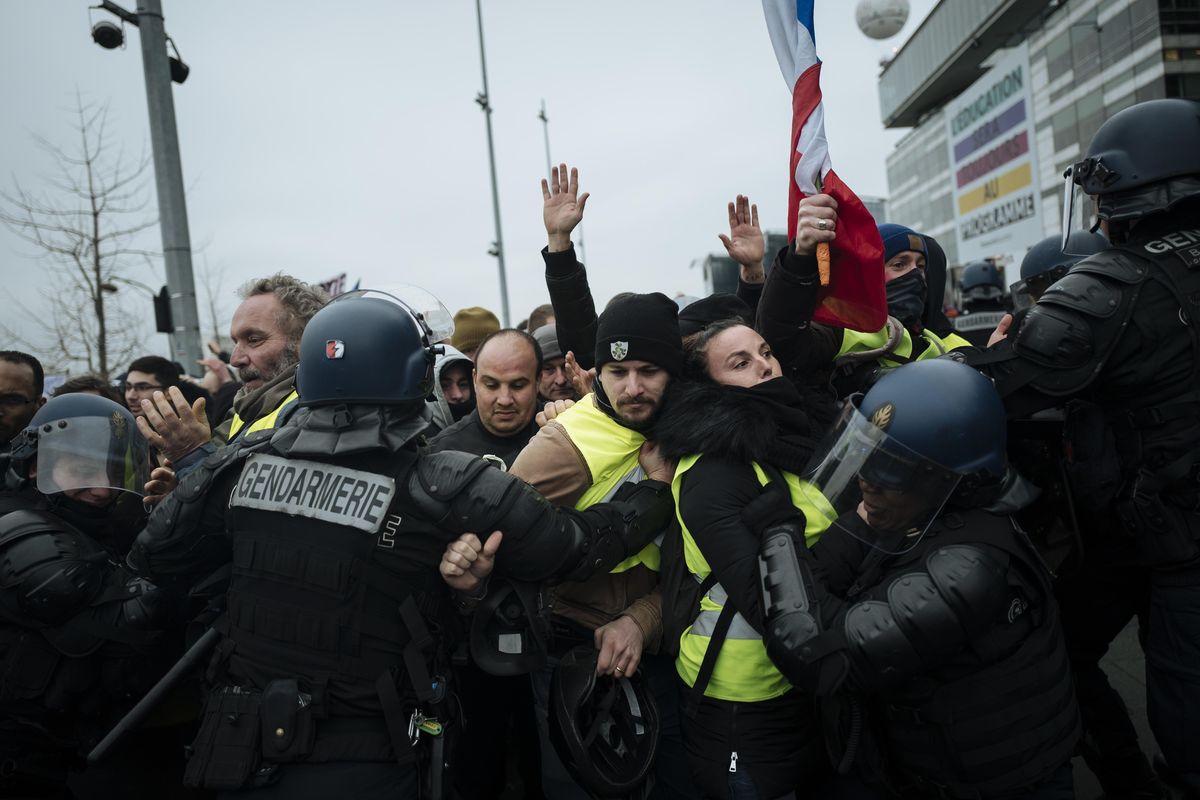 French riot police officers hold back demonstrators wearing yellow vests as they demonstrate in front of the french public television network in Paris, Saturday, Dec. 29, 2018. Yellow vest protesters marched on the headquarters of leading French broadcasters Saturday, as small groups turned out around France despite waning momentum for their movement. Another small group of yellow vest demonstrators gathered near the Eiffel Tower, and police arrested several, but by nightfall, calm returned to the Trocadero plaza overlooking the tower. (Kamil Zihnioglu / AP)