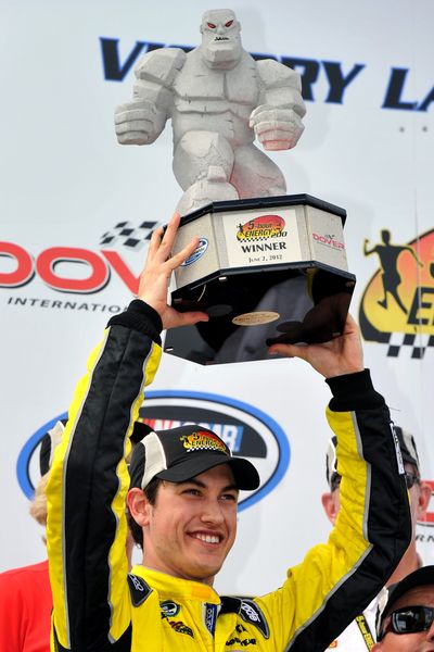 Joey Logano hoists the trophy in victory lane after winning the NASCAR Nationwide Series auto race at Dover International Speedway. (Associated Press)