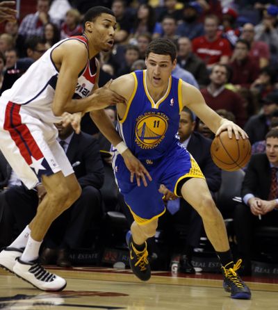 Golden State’s Klay Thompson, driving past Washington’s Otto Porter Jr., scored 26 points to lead the Warriors. (Associated Press)
