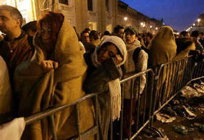 
Mourners wrap themselves in blankets on the road leading to St. Peter's Square at the Vatican early Wednesday to say farewell to Pope John Paul II. 
 (Associated Press / The Spokesman-Review)