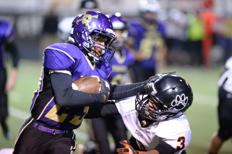 Rogers' Marcus Phillips, left, carries a kickoff return while pursued by Lewis and Clark's defensive back Marcus Ducham, right, Friday, Oct. 11, 2013 at Joe Albi Stadium. (Jesse Tinsley / The Spokesman-Review)