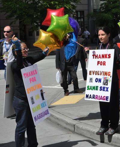 SEATTLE -- Teri McClain, left, and Mary Beth Brotski wear signs thanking President Barack Obama for supporting gay marriage. (Jim Camden)