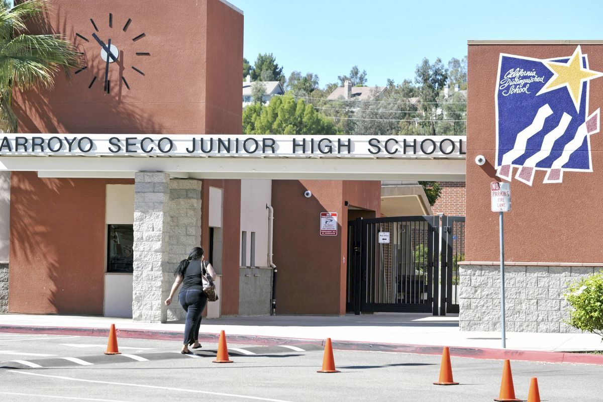 An unidentified woman walks into Arroyo Seco Junior High School in the Valencia neighborhood of Santa Clarita, Calif., Tuesday, Sept. 18, 2012.  Eric Yee, accused of posting comments on ESPN