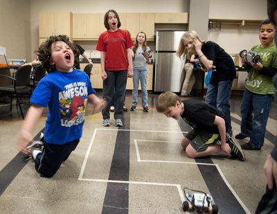 Maybe next time: Ronan Caine, 9, left, and Duncan Sullivan, 10, kneeling at right, react as their robot car’s tire exceeds the taped boundary on the demonstration course Monday at the Mobius Science Center’s Enter the Robopocalypse class. From left, Ben Asbury, 11, Tessa Neumann, 10, Mason Leisenring, 10, and Dominick Macauley, 9, watch the action. Students programmed the robots to stay inside the taped area. The robot succeeded on the next try. Twenty third- through fifth-graders are participating in the two-day class during spring break. For other spring break camps and events, go to www.spokesman.com/stories/2013/mar/28/family-calendar. (Dan Pelle)