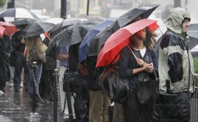 
People wait at a taxi stand in driving rain outside Pennsylvania Station in New York on Wednesday.  
 (Associated Press / The Spokesman-Review)
