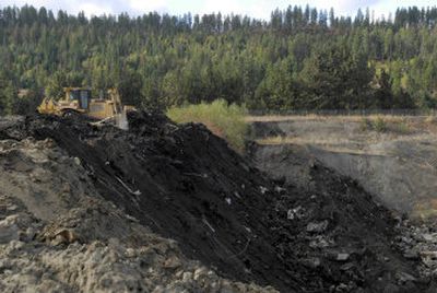 
A bulldozer pushes fill dirt mixed with concrete and wood  waste into a large pit left behind by Central Pre-Mix on Thursday at what is now part of the Riverstone development. 
 (Jesse Tinsley / The Spokesman-Review)