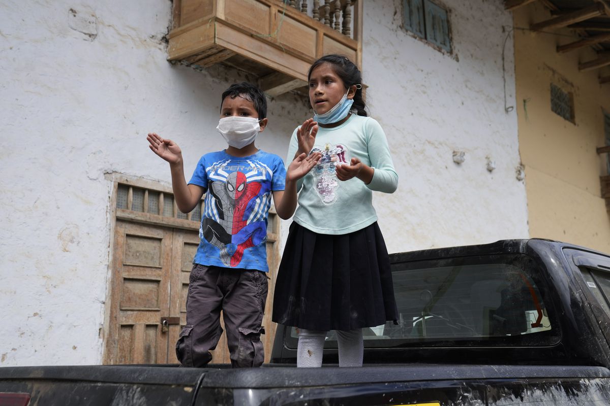 Children applaud as presidential candidate Pedro Castillo walks along Tacabamba, Peru, after voting Sunday, June 6, 2021. Peruvians vote Sunday in a presidential run-off election to choose between Castillo, a political novice who until recently was a rural schoolteacher, and Keiko Fujimori, the daughter of jailed ex-President Alberto Fujimori.  (Martin Mejia)