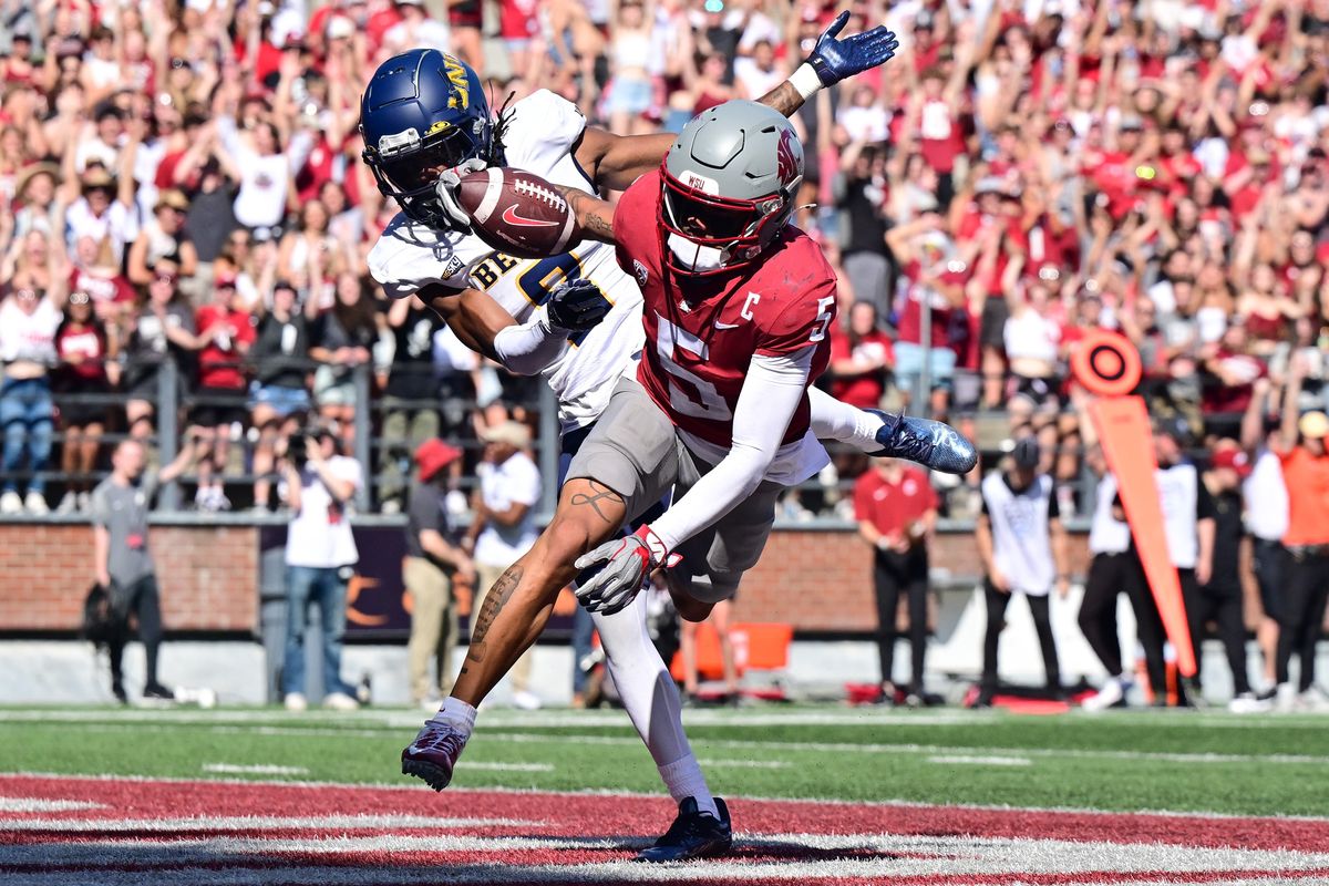 Washington State Cougars wide receiver Lincoln Victor (5) leaps into the endzone for a touchdown over Northern Colorado Bears defensive back Tizell Lewis (8) during the first half of a college football game on Saturday, Sept. 16, 2023, in Pullman, Wash.  (Tyler Tjomsland/The Spokesman-Review)