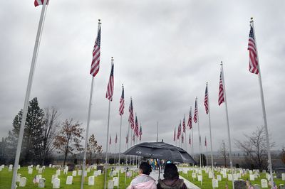 Dozens of flags decorate the Fort Wright Military Cemetery in Spokane on Tuesday as people gather for a  Veterans Day ceremony.  (CHRISTOPHER ANDERSON / The Spokesman-Review)