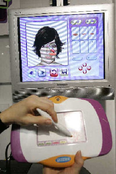 
Stephanie Bennett demonstrates Digi Makeover at the Radica showroom in the American International Toy Fair earlier this year. Using a touch pad and a digital camera connected to the TV, children can perform a virtual makeover, changing hairstyles, makeup and accessories. 
 (Associated Press / The Spokesman-Review)