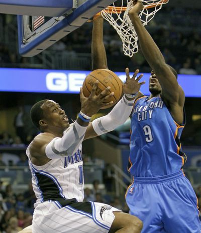 Orlando Magic center Dwight Howard, left, goes to the basket against Oklahoma City Thunder's Serge Ibaka. (Associated Press)