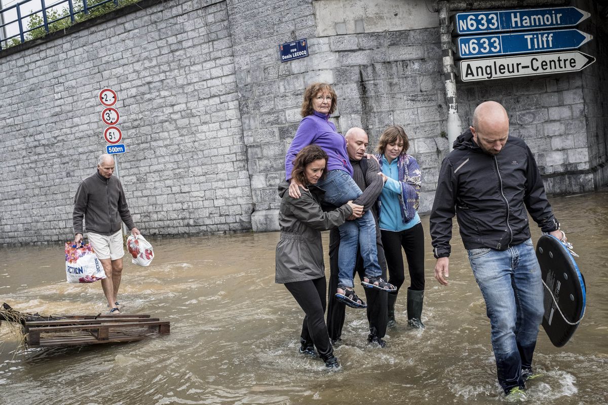 A woman is carried through a flooded street in Angleur, Province of Liege, Belgium, Friday. (Valentin Bianchi)