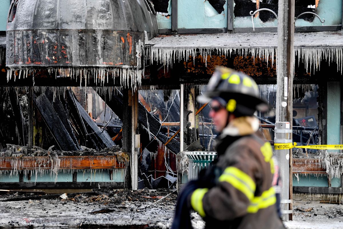 Fire crews work at the site of a fire in downtown Sandpoint that destroyed as many as five local businesses is seen on Monday, February 11, 2019, in Sandpoint, Idaho. (Tyler Tjomsland / The Spokesman-Review)