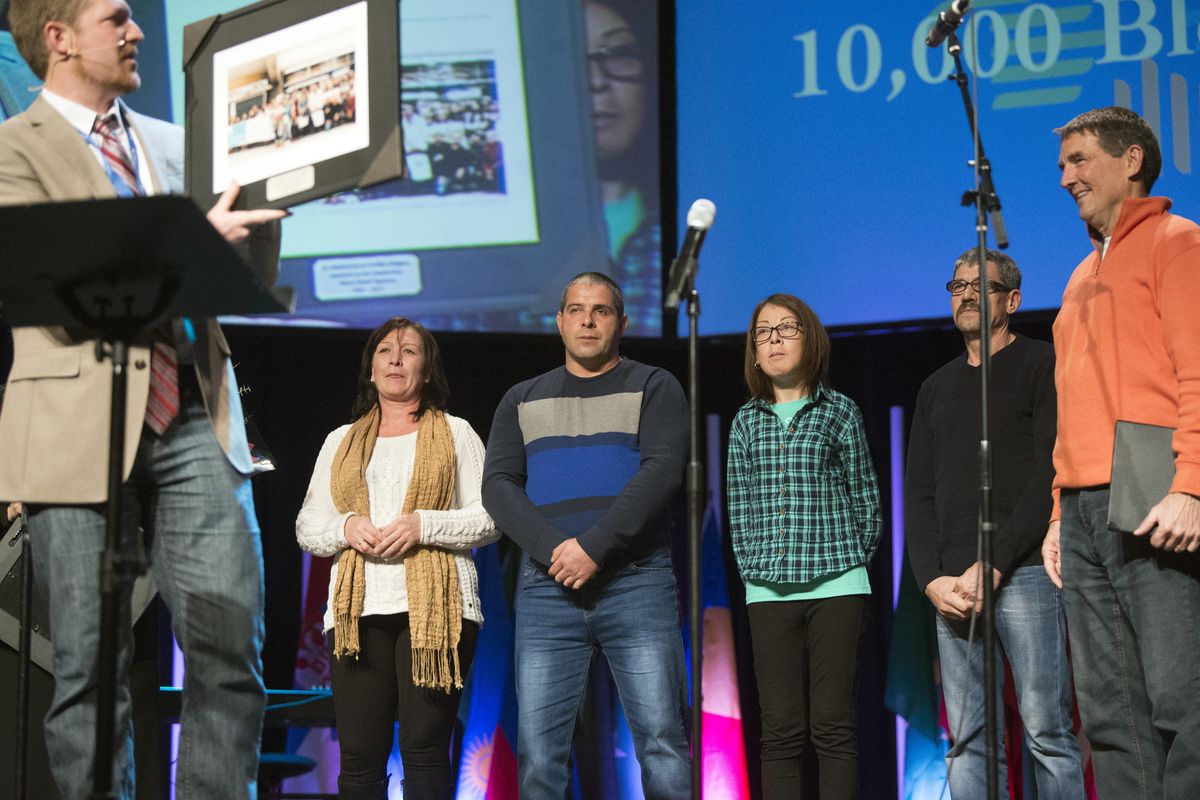 A family of four from Moldova, center, represent the 10,000th refugee settled in Spokane at a service Sunday, Nov. 19, 2017, at Life Center Church, where World Relief Spokane Director Mark Finney, left, and Pastor Joe Wittwer, right, celebrated the milestone. (Jesse Tinsley / The Spokesman-Review)
