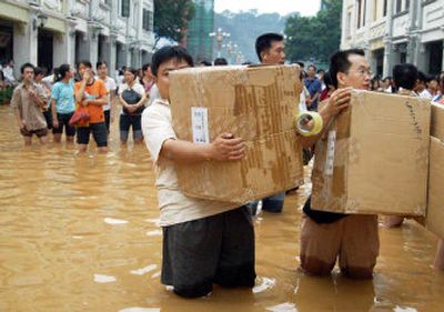 
Chinese residents carry their belongings as they evacuate their homes Wednesday in a flooded area in Wuzhou city, in southwest China's Guangxi region. About 570,000 people were evacuated from flood-prone areas in Guangxi. 
 (Associated Press / The Spokesman-Review)