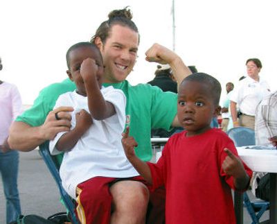 
Steve Gleason of the New Orleans Saints poses with some of his young fans in San Antonio in September 2005, during his 