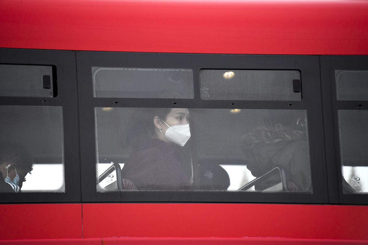 A woman wears a face mask as she sits on a bus, in London, Wednesday, Oct. 7, 2020. Like other countries in Europe, the U.K. has seen rising coronavirus infections over the past few weeks, which has prompted the government to announce a series of restrictions, both nationally and locally, to keep a lid on infections.  (Alberto Pezzali)