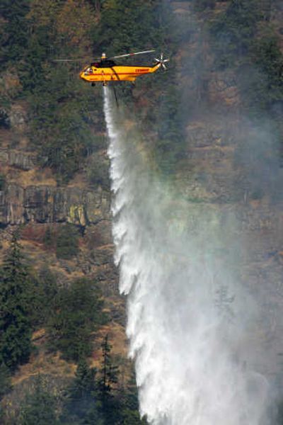 
Helicopters use water from the Columbia River on Friday to fight a wildfire that burned five homes near White Salmon, Wash. Associated Press
 (Associated Press / The Spokesman-Review)
