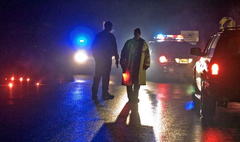 Police stopped traffic on Meridian Ave. about a mile north of a triple-shooting near Tanwax Lake, Pierce County, Monday night, December 21, 2009. Two sheriff's officers responding to a dispute between two brothers were shot by one of the men lying in wait after being welcomed into the home by the other, authorities said. The gunman was killed and the officers were seriously wounded. (AP Photo/The News Tribune, Peter Haley) (Peter Haley / The News Tribune)