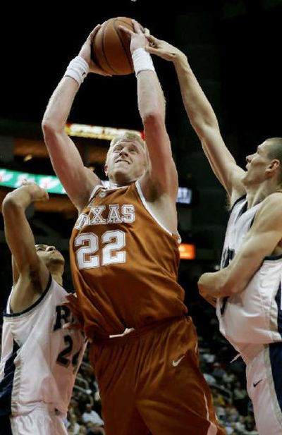 
Texas' Brad Buckman shoots as Rice's Jamaal Moore, left, and Aleks Perka defend during the second half in Houston. 
 (Associated Press / The Spokesman-Review)