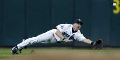 
Seattle Mariners second baseman Willie Bloomquist dives in vain to field a grounder by Orlando Cabrera in the first inning. Associated Press
 (Associated Press / The Spokesman-Review)
