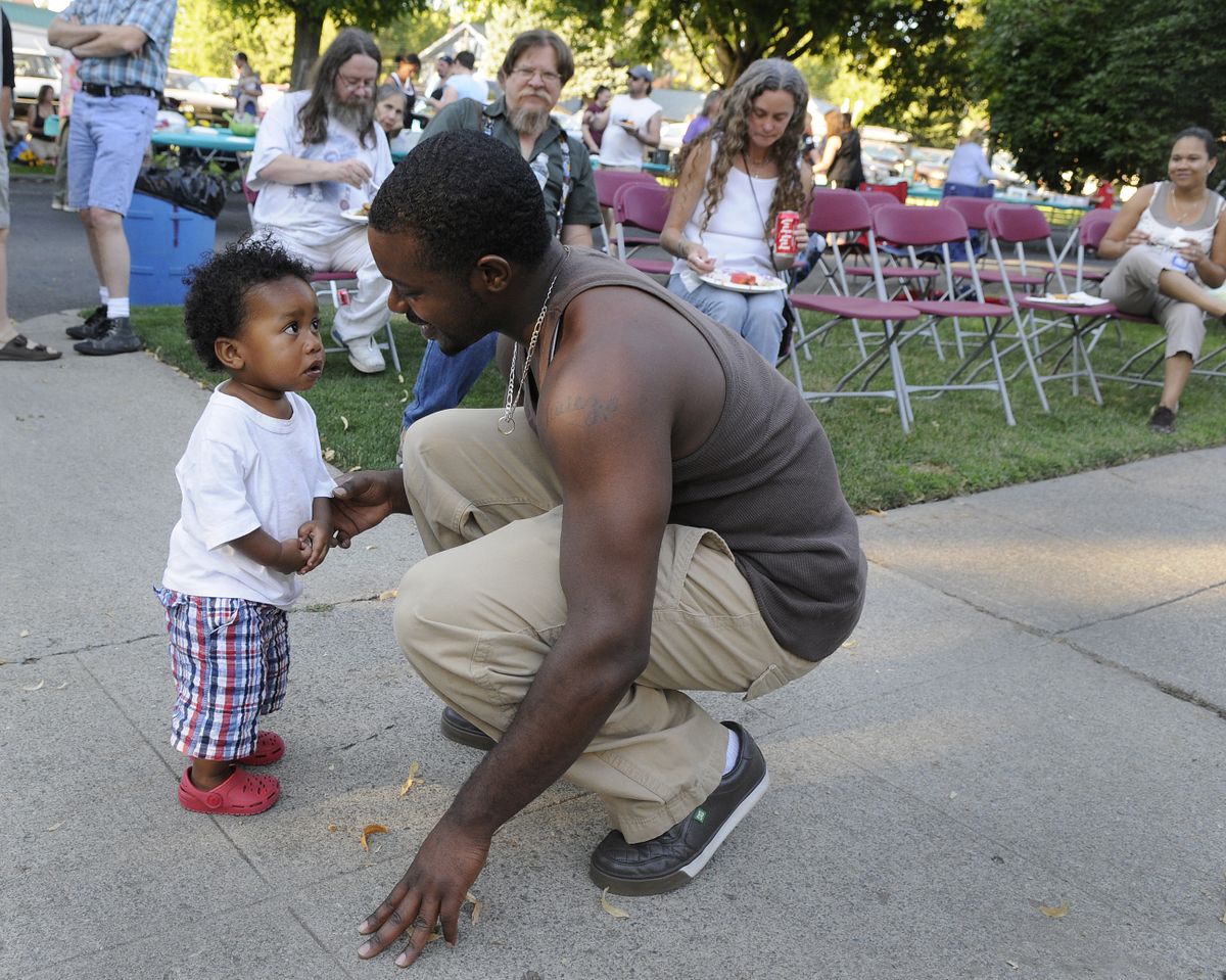 Antwan Bowens chats with his son, Kahree, 15 months, as the boy dances to  music  during the gathering at 10th and Monroe. (Dan Pelle / The Spokesman-Review)
