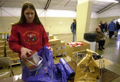 
Janelle Atyeo, a Gonzaga University senior, helps bag Christmas gifts Monday at the Christmas Bureau. 
 (Liz Kishimoto / The Spokesman-Review)