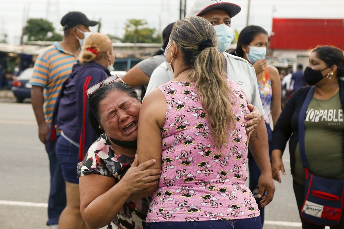 Relatives of inmates cry outside the Centro de Privación de Libertad Zona 8 prison where riots broke out in Guayaquil, Ecuador, Tuesday, Feb. 23, 2021. Deadly riots broke out in prisons in three cities across the country due to fights between rival gangs, according to police.  (Angel Dejesus)