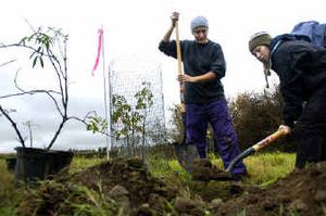 
Sisters Brandie Hill, left, and Naomi Kassner, 18, a student at Cheney Alternative High, dig a hole for an elderberry tree at Turnbull Wildlife Refuge on Saturday. 
 (Holly Pickett / The Spokesman-Review)