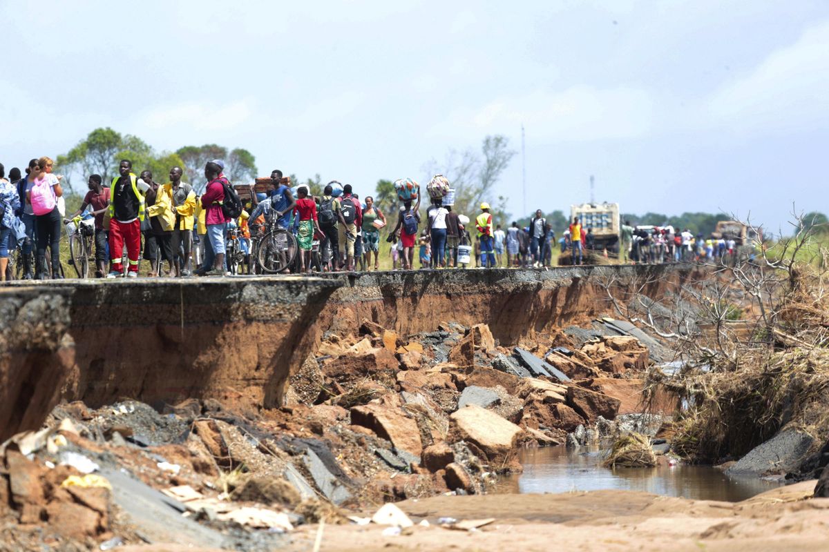 People pass through a section of the road damaged by Cyclone Idai in Nhamatanda about 31 miles from Beira, in Mozambique on Friday, March, 22, 2019. As flood waters began to recede in parts of Mozambique on Friday, fears rose that the death toll could soar as bodies are revealed. (Tsvangirayi Mukwazhi / Associated Press)