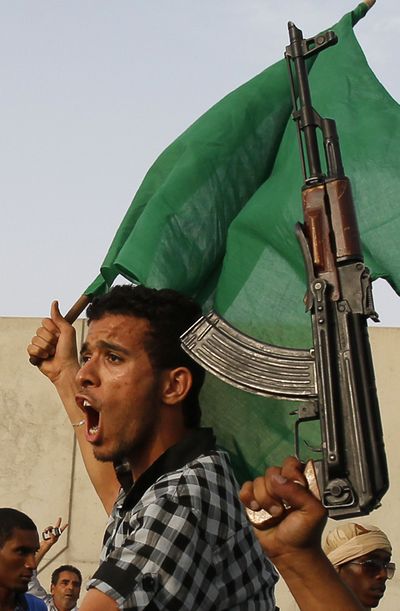 A Libyan man shouts as he and others rally to show their support for their leader, Moammar Gadhafi. (Associated Press)