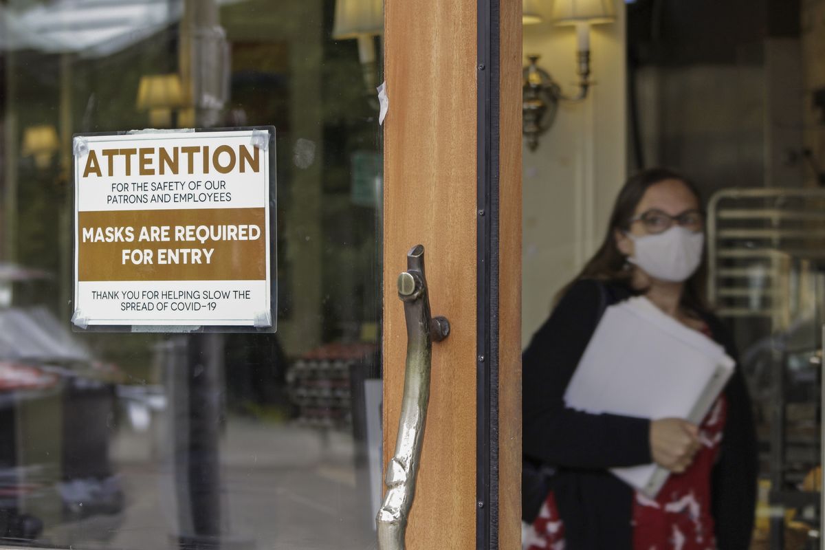In this May 21, 2021 photo, a sign reminds customers to wear their masks at a bakery in Lake Oswego, Ore. Oregon Gov. Kate Brown on Tuesday, Aug. 10, 2021 announced a statewide indoor mask requirement due to the spike in COVID-19 hospitalizations and cases, warning that the state